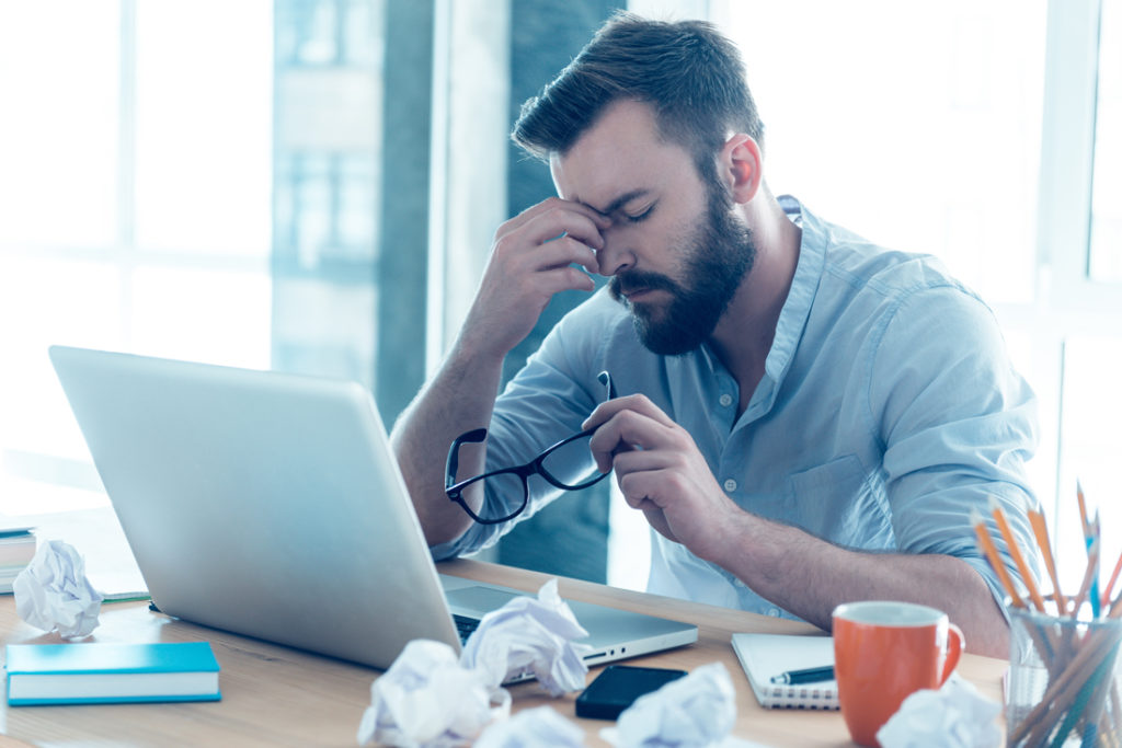 Photo of stressed guy at desk perhaps dealing with a recession