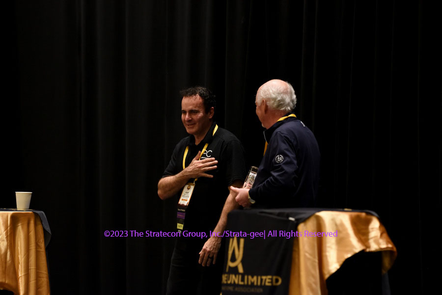 Azione President Richard Glikes presents a special award to departing board member Alex Camara of AudioControl